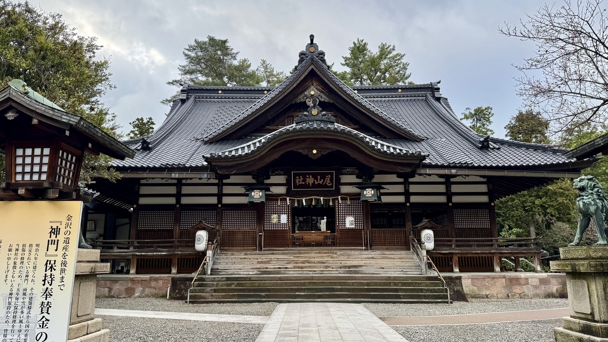 尾山神社の拝殿と参道脇の狛犬