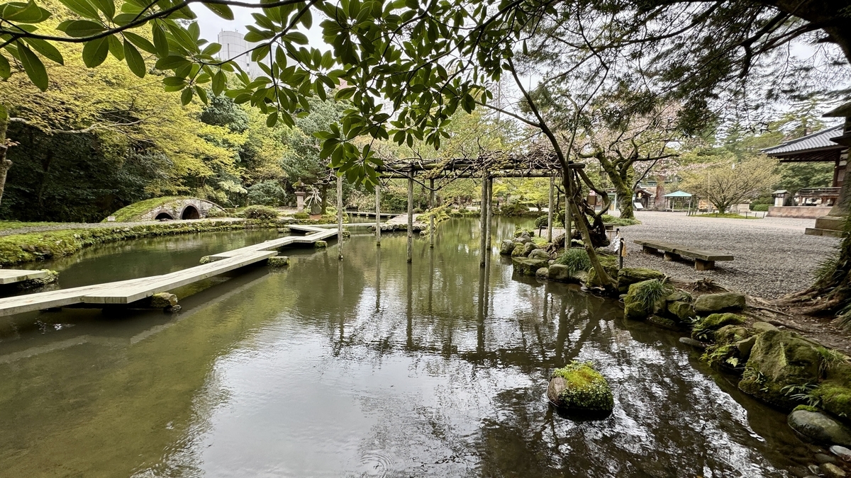 尾山神社神苑の池と水面に映る藤棚