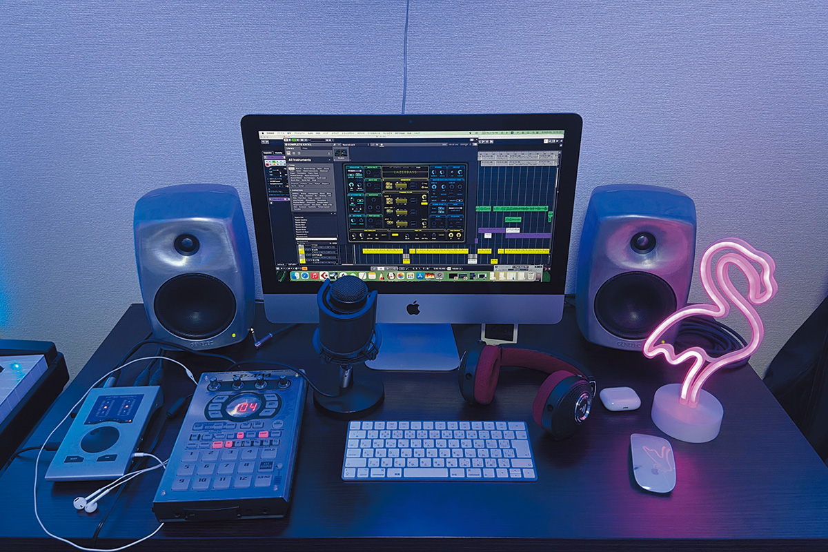 デスクにはAPPLE iMac、その画面にはSTEINBERG Cubaseが映し出されている。モニター・スピーカーはGENELEC 8330A、オーディオ・インターフェースのRME Babyface Pro FSにはAPPLE iPhone純正イアフォンを接続。そのほか、サンプラーのROLAND SP-404、マイクのAUDIO-TECHNICA AT2020、開放型ヘッドフォンのFOCAL Clear MG Proなどが用意されている