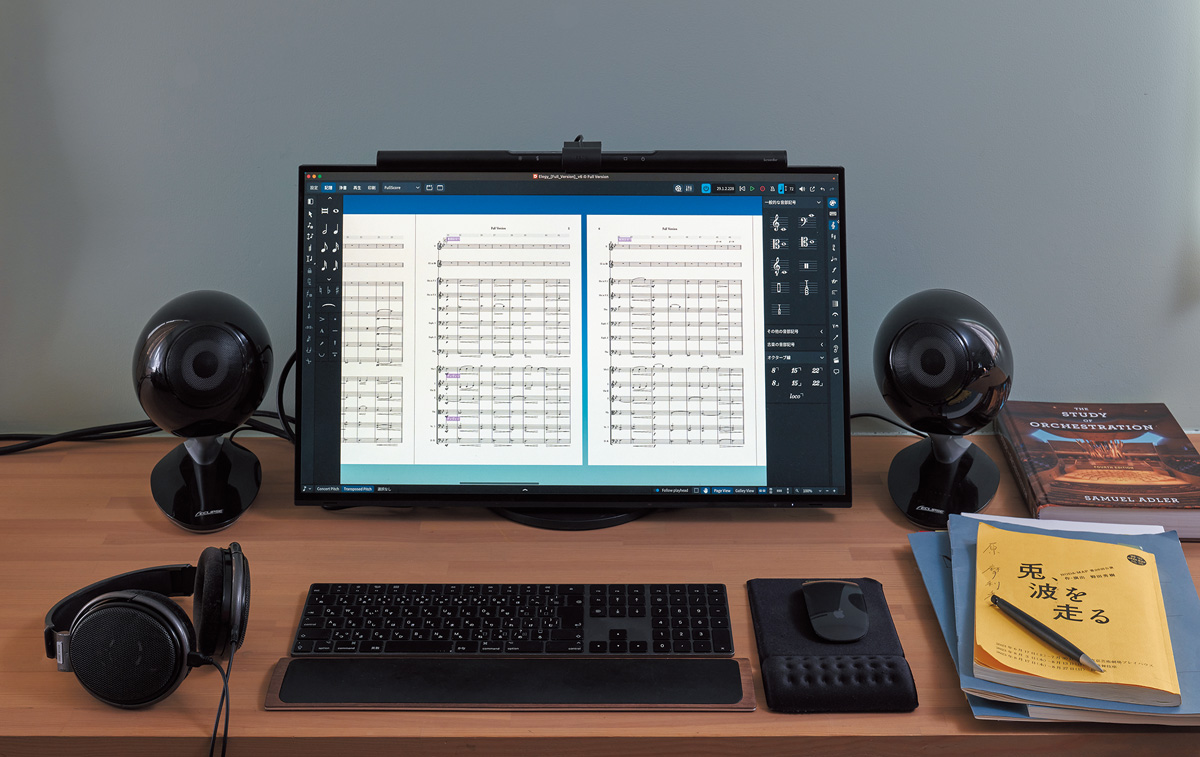 右側のデスクはモニター・スピーカーECLIPSE TD-M1を設置。画面には楽譜作成ソフトSTEINBERG Doricoが起動。ヘッドフォンはSENNHEISER HD 650。右奥は、原が「何回やってもうまくいかなかったオーケストレーションがこれですんなり理解できた」と話す書籍『The Study of Orchestration』（サミュエル・アドラー著）