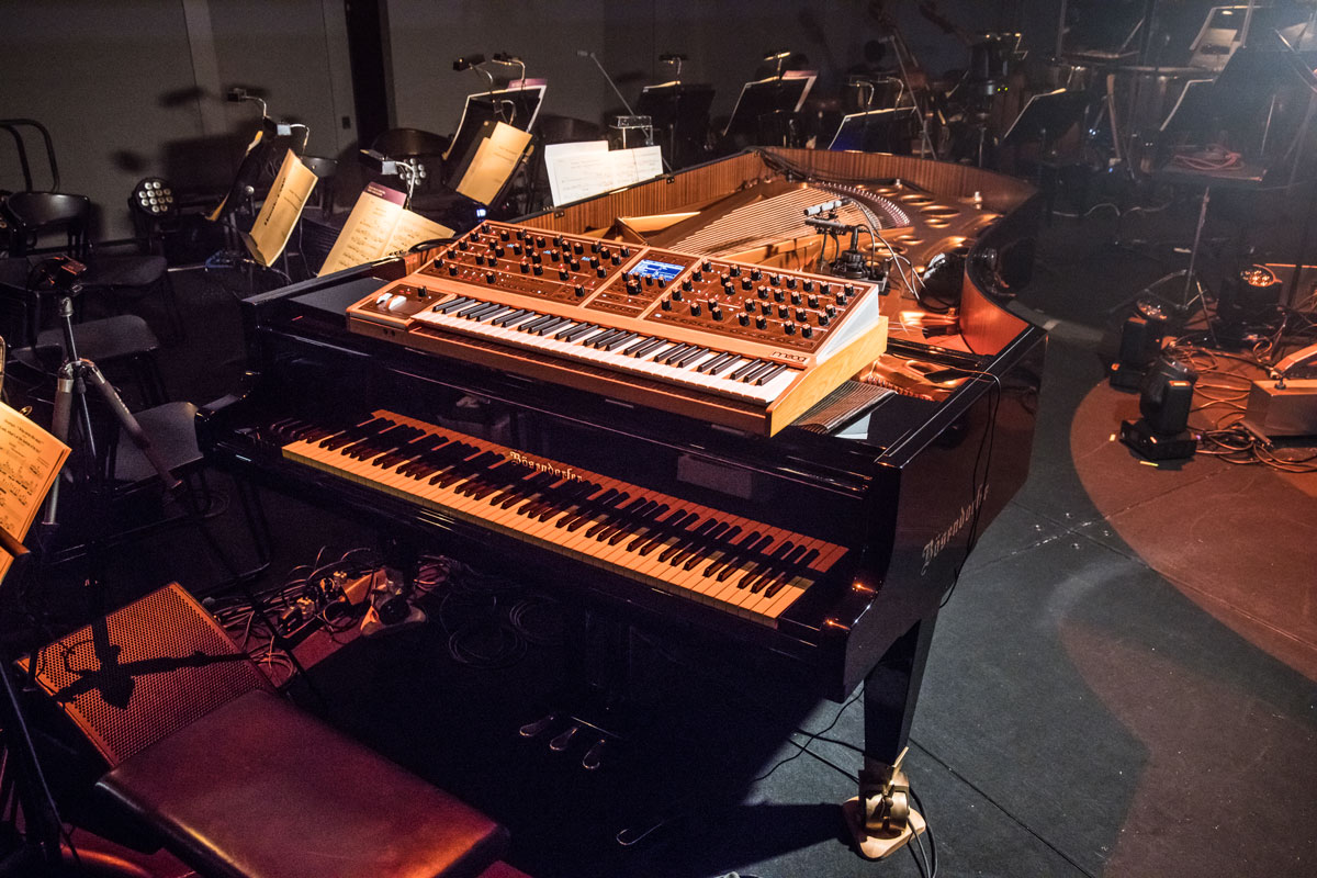 渋谷が演奏するピアノには、ハンマー付近へNEUMANN MCMをL/Rに、少し離れたところへSCHOEPS CMC 64をX/Yステレオに設置したほか、響板の響きを狙うAUDIO-TECHNICA ATM35、ホールに突っ込んだSENNHEISER MKH 40をマイキング。オルタ4との即興用に山彦のピックアップも用いられた。上のシンセはMOOG Moog One（Photo：Hiroki Obara）