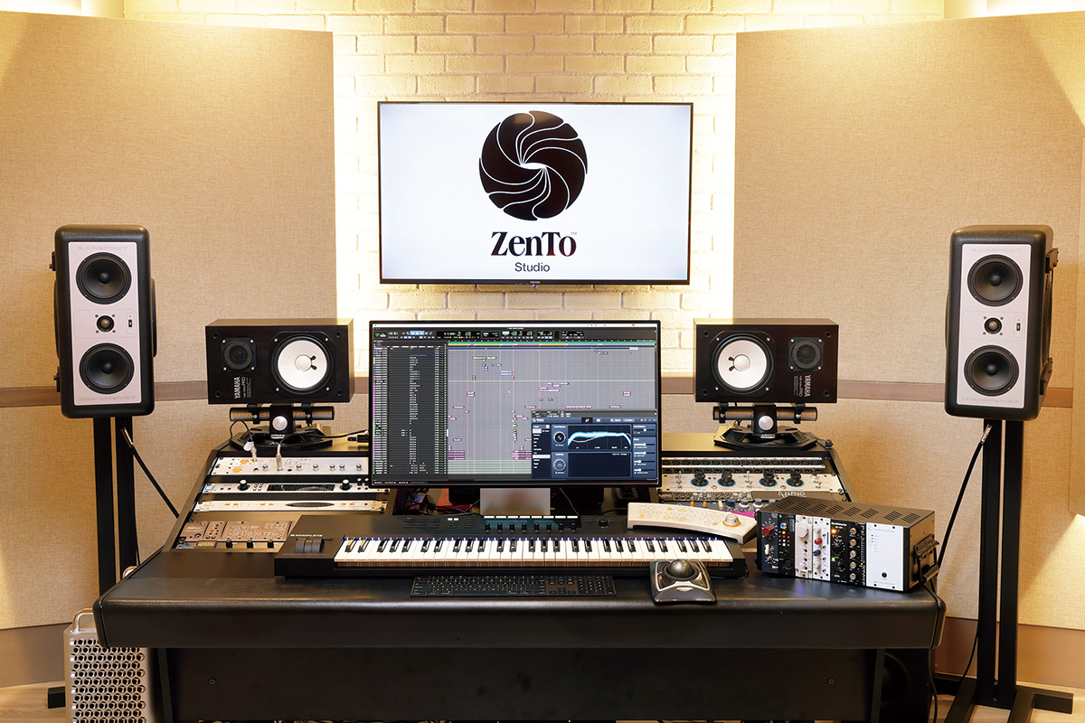 コントロール・ルームのデスク。センターにはMIDIキーボード、NATIVE INSTRUMENTS Komplete Kontrol S61 MK2がセットされ、左右にそれぞれ機材が格納されている（後述）。コンピューターはAPPLE Mac Proで、16コア3.2GHz、192GB RAMのスペックを装備。AVID Pro Tools｜HDX用インターフェースには、PRISM SOUND ADA-8XRを採用している