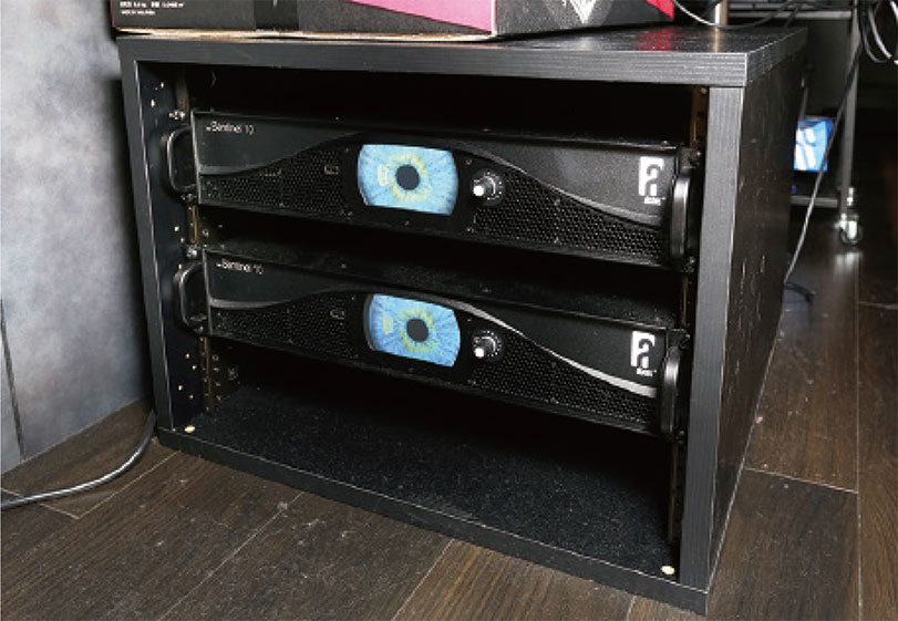 PAブースのコンソール下にあるメイン・スピーカー用パワー・アンプAlcons Audio ALC Sentinel 10。スピーカー・ケーブルを長く引き回した際の補正を行うSISのおかげでPAブースに設置でき、ステージを広く活用できるという利点もあるとのことだ