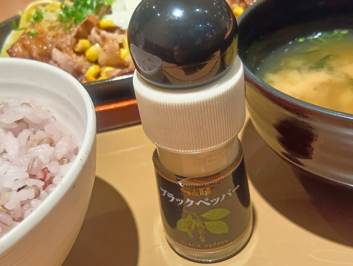 やよい軒の定食に付属するもち麦ごはん、味噌汁、卓上ブラックペッパーミルのクローズアップ。