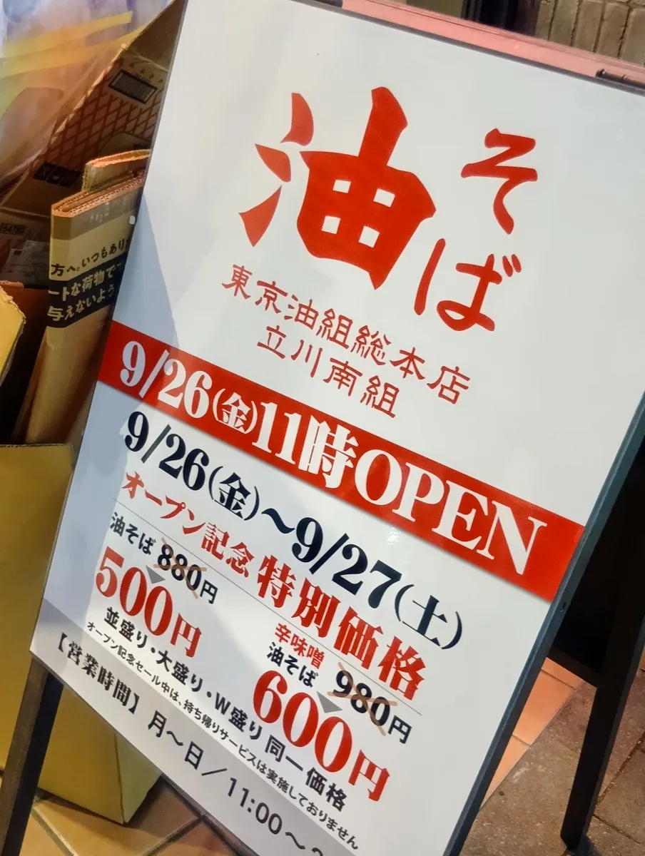 油そば 東京油組総本店 立川南組のオープン告知看板。9月26日(金)11時オープンと特別価格500円の案内。