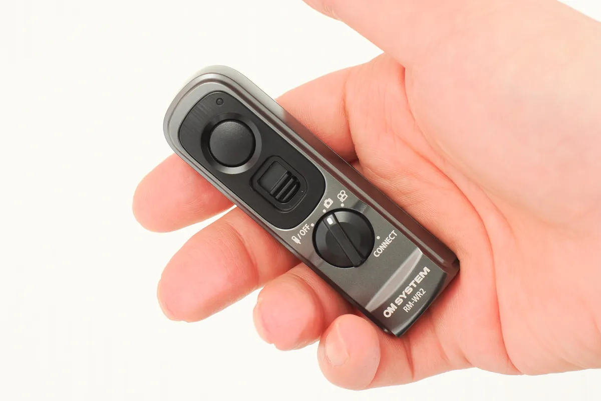 手のひらにすっぽり収まるOM SYSTEM RM-WR2ワイヤレスリモコンを握る手