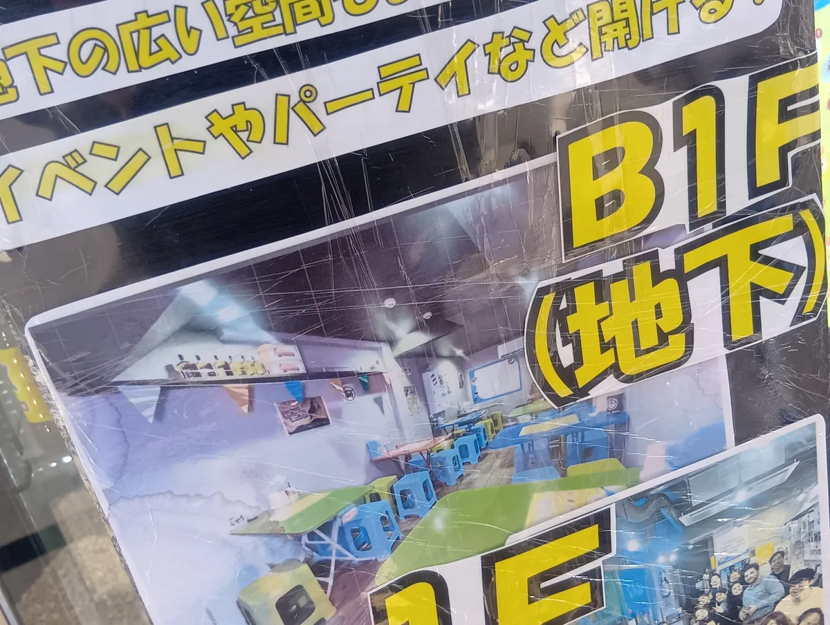 「B1F（地下）」と書かれた案内看板。地下フロアの店内の様子が写真で示されており、広々とした空間にテーブルと椅子が並んでいる。