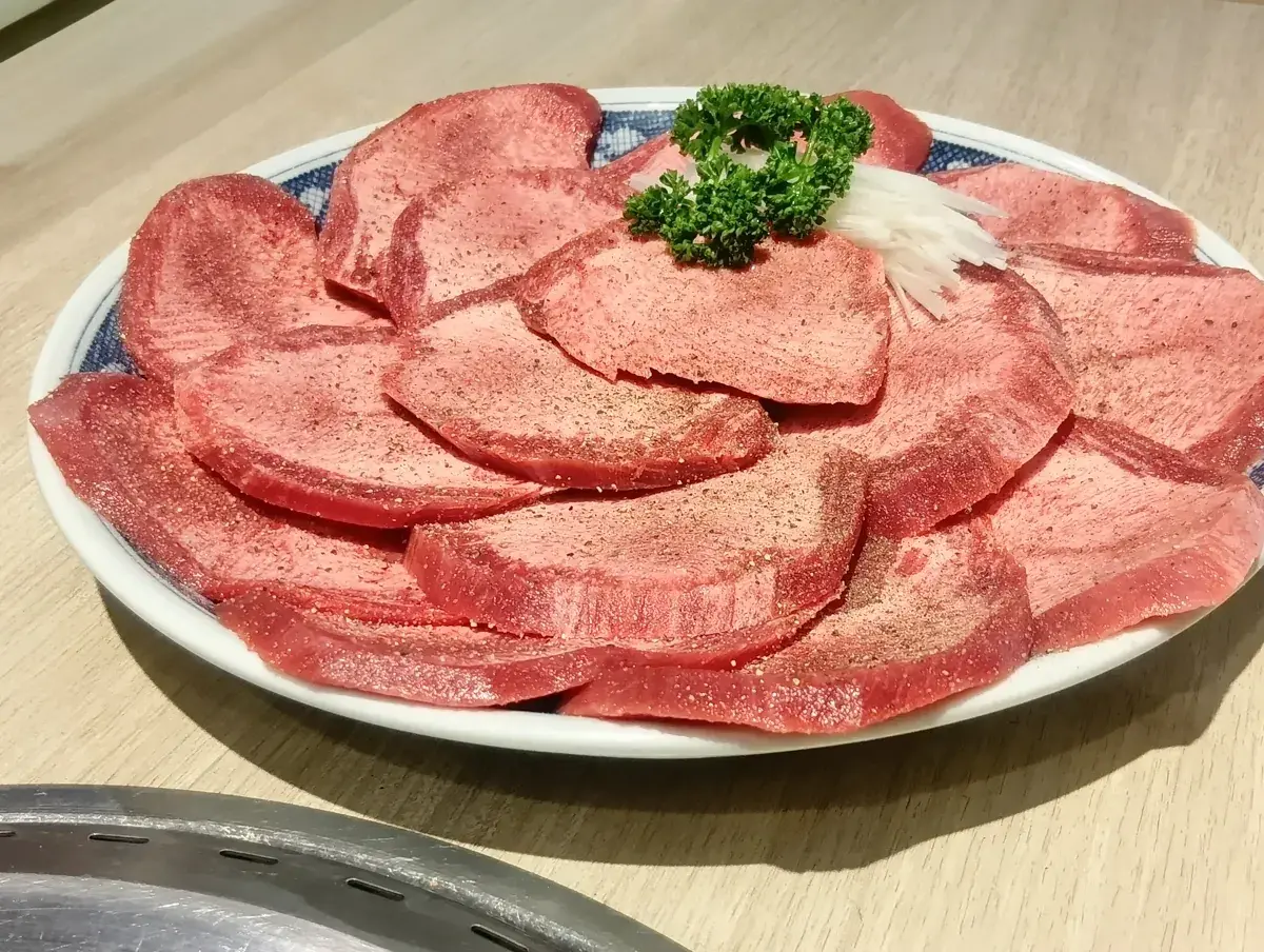 白い皿に盛られた厚切りの上たん塩。美しいピンク色の身にきめ細かなサシが入っている