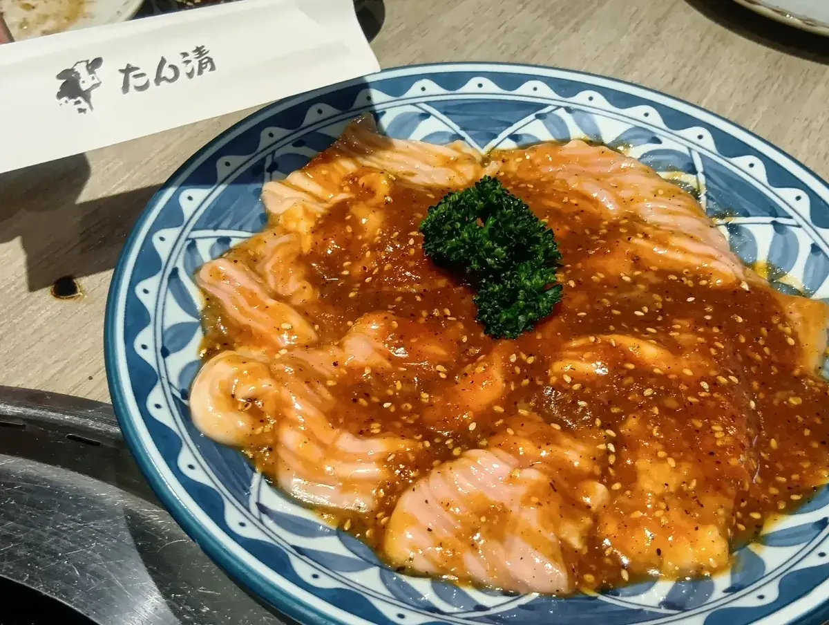 青い皿に盛られたホルモン（味噌）。濃厚なタレがたっぷりとかかっている