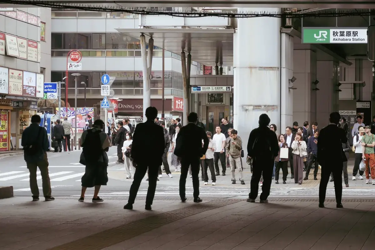 秋葉原駅ガード下。逆光の中に6人の男性がシルエットで立ち並び、出撃を待つ戦隊ヒーローのような緊迫感がある。