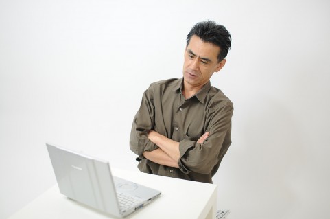 それ、どこ情報? PCを見て怪しんでいる男の写真