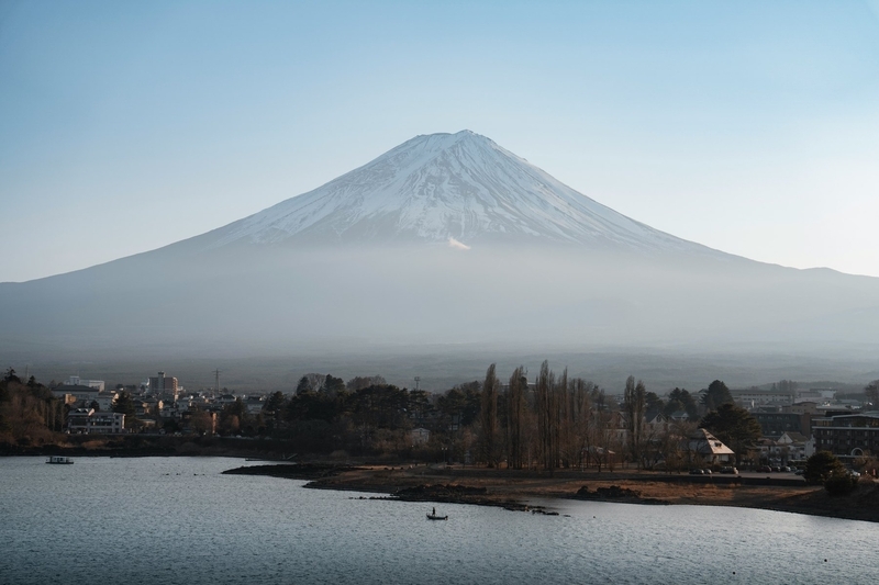 霧がかかった町並みの向こうにそびえる富士山と静かな湖 霧がかかった町並みの向こうにそびえる富士山と静かな湖