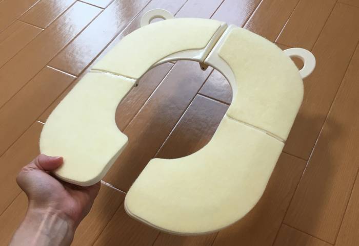 補助便座を持ち上げているところ