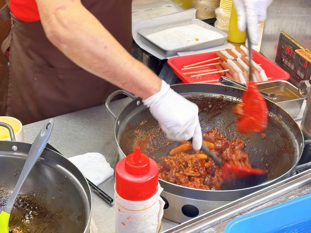 新大久保で韓国グルメを食べ歩きの写真　カマロカンジョン　店先でタッカンジョンを作る様子