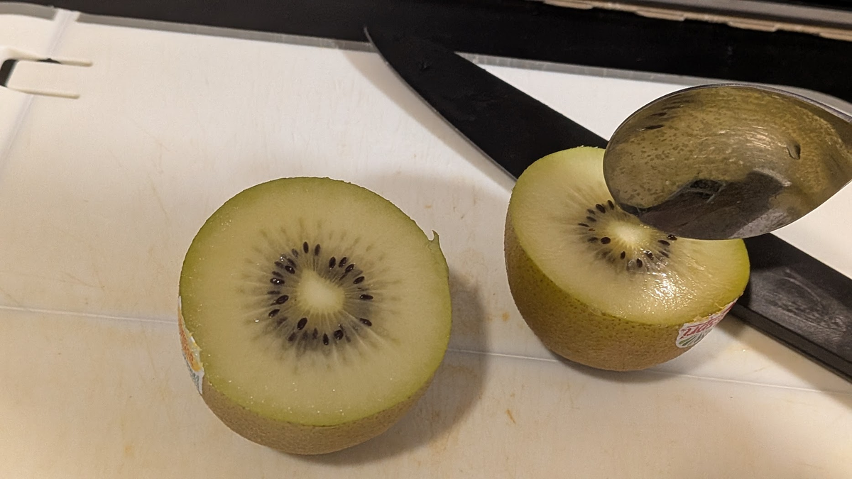 半分に切ったキウイにスプーンをさす