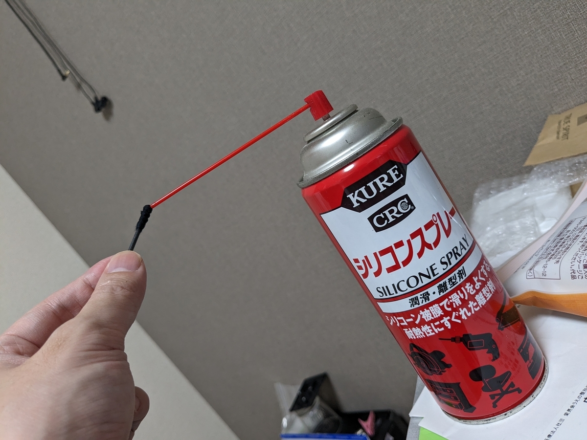 綿棒にシリコンスプレーを吹き付ける図