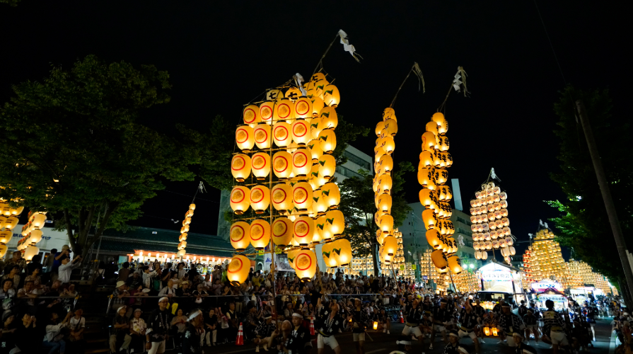 秋田竿燈まつり。数十本の竿が夜の大通りに一斉に立ち並ぶ