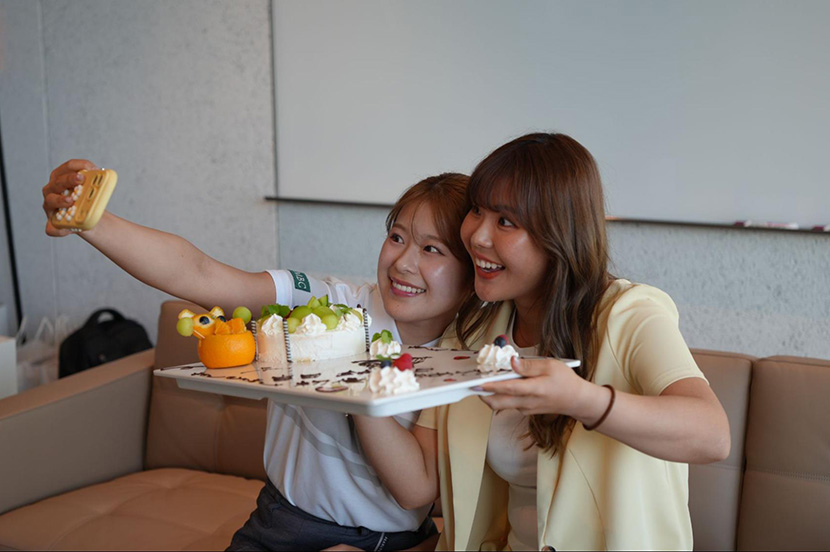 ケーキを囲んで撮影する吉田鈴プロと吉田優利プロ