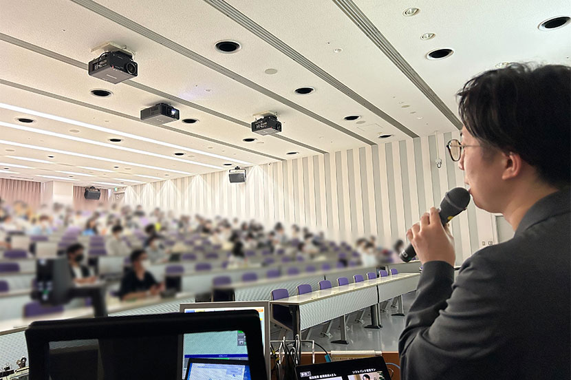 母校の後輩にプロジェクトの説明をする様子