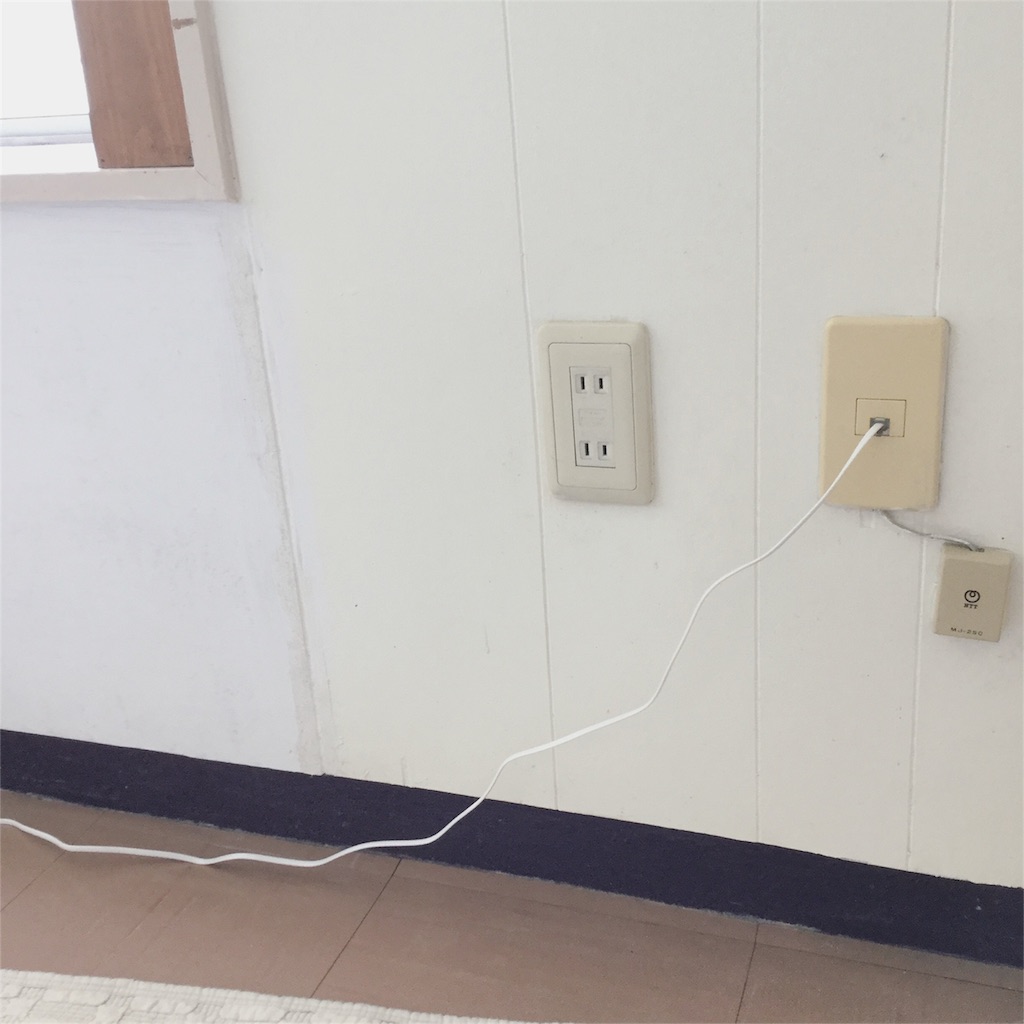 ネット回線のモデムにつないでいる電話線がだらしなく垂れている様子 ネット回線のモデムにつないでいる電話線がだらしなく垂れている様子
