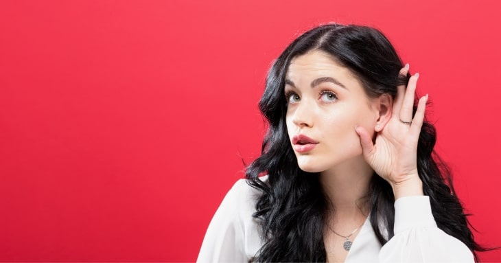 耳をすませて注意深く聞いている女性