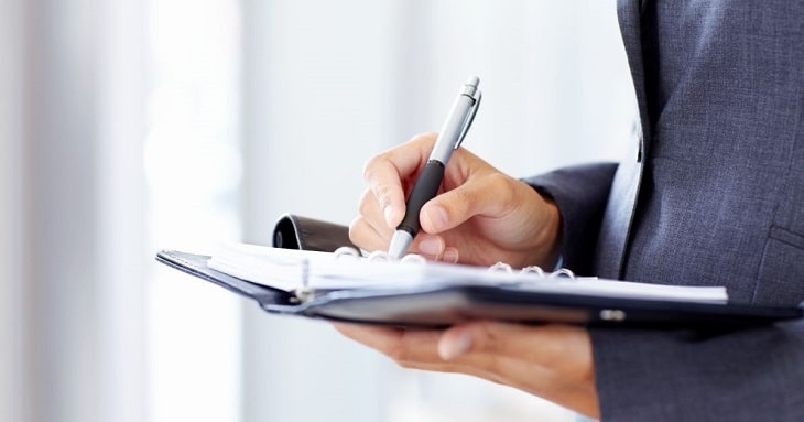 手帳に書き込みをしている、仕事の速いビジネスパーソン