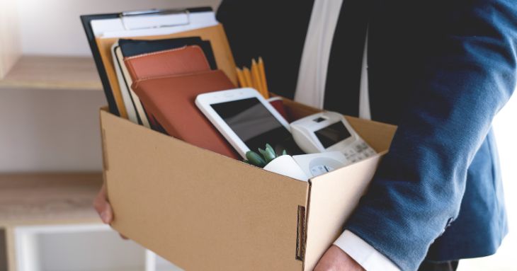 事務用品が入った段ボールを手に持つ人の手元
