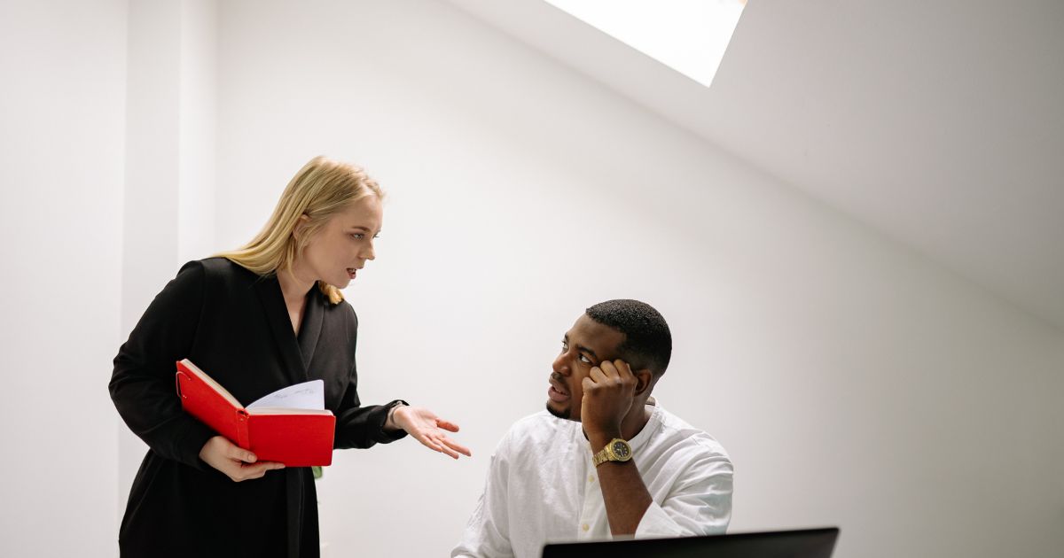 職場で楽しくなさそうな会話をする男女