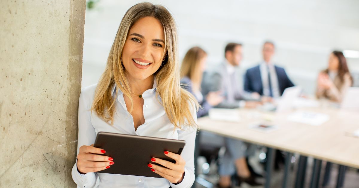 タブレットを手に持つ、にこやかなビジネスパーソン