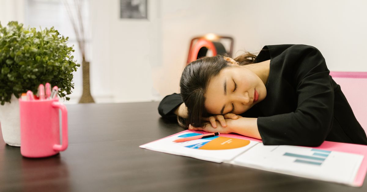 デスクで仮眠をとるビジネスパーソン