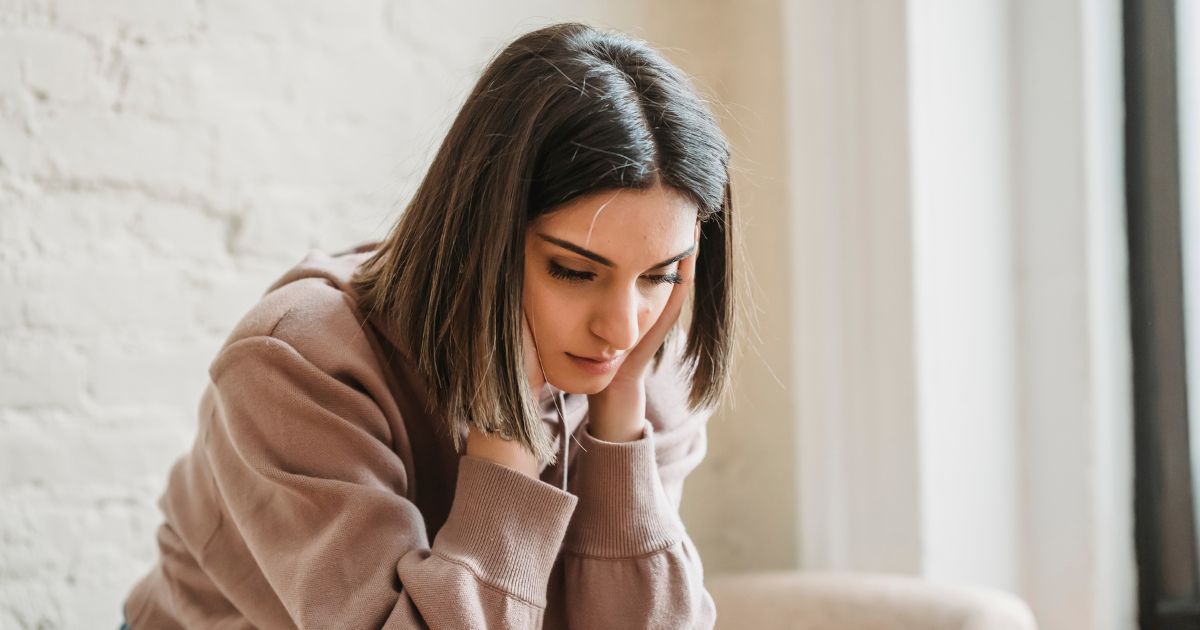 悩んでいる様子の座った女性