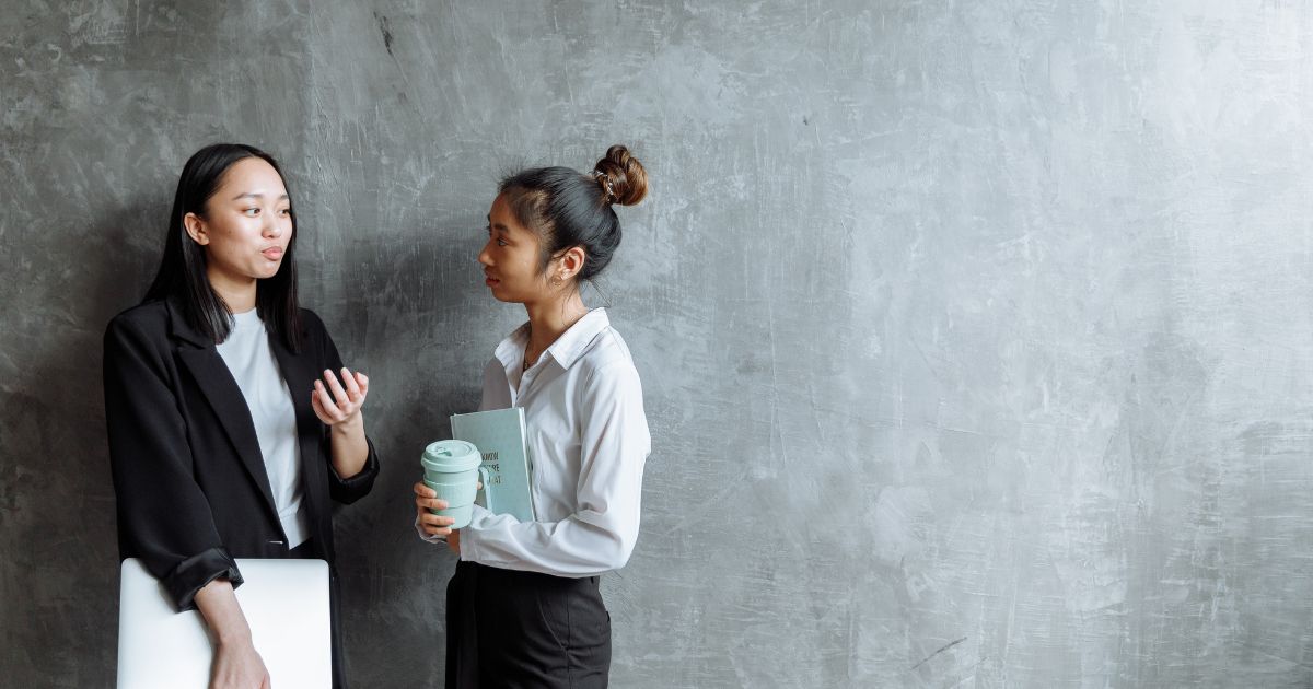 立って話をするふたりのビジネスパーソン