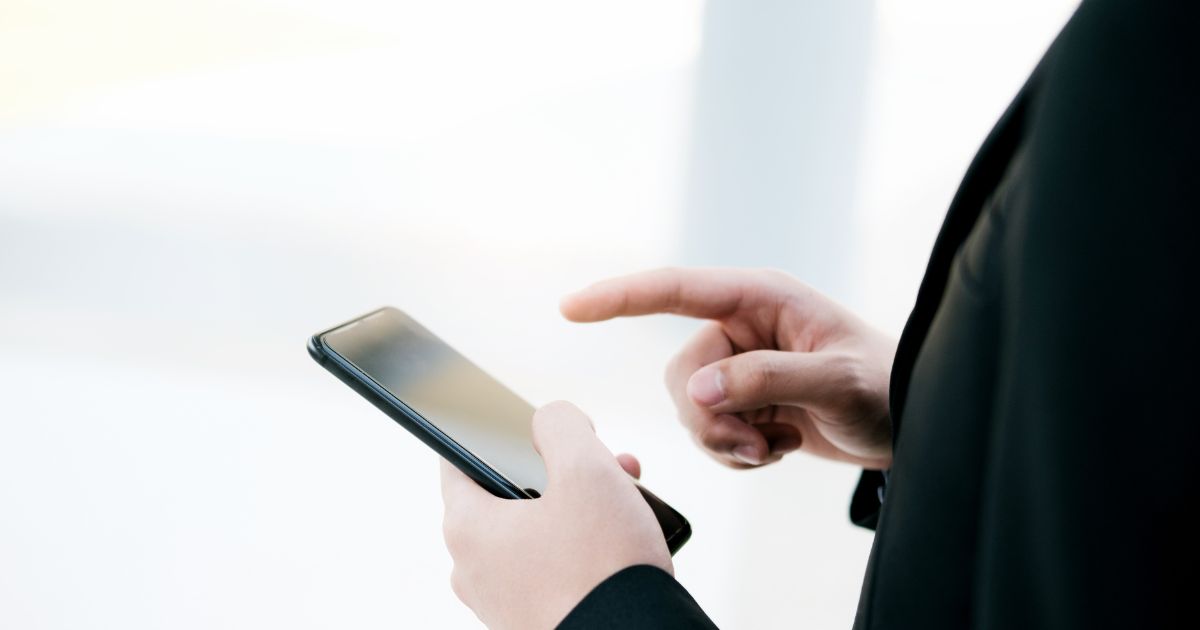 スマートフォンを手にするビジネスパーソン