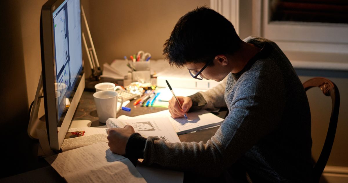 夜にデスクで勉強する人