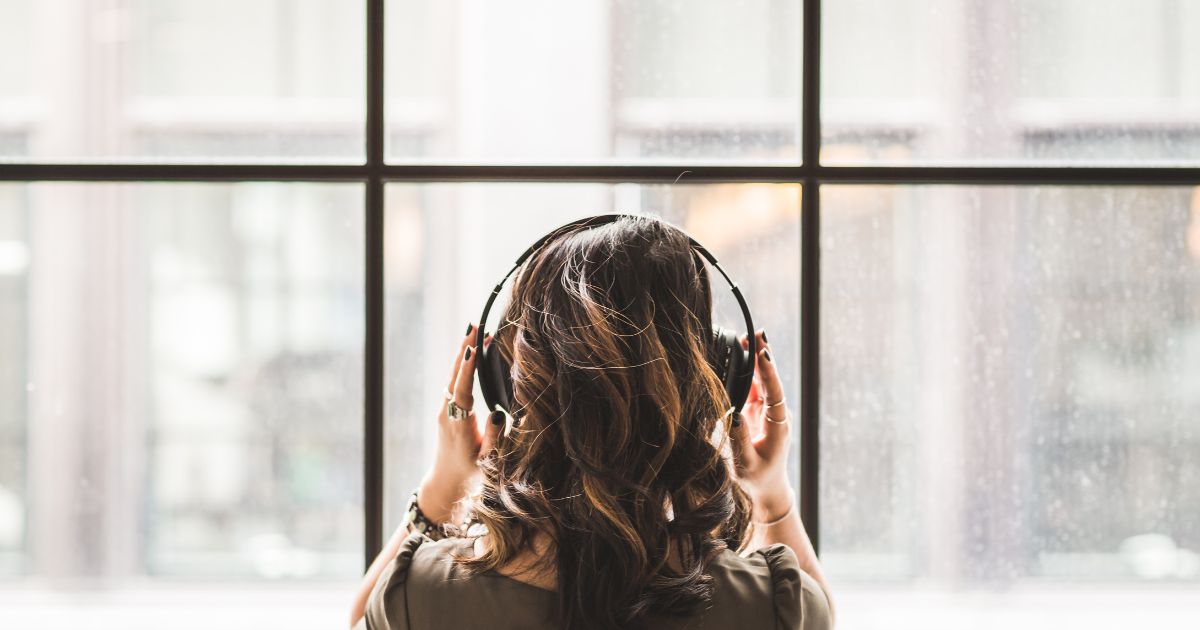 ヘッドホンをつけて音楽を聞くビジネスパーソン