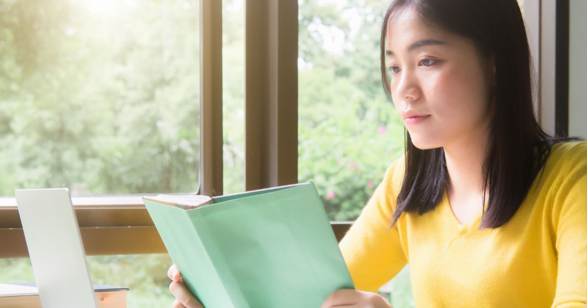 本を読む黄色の服を着たビジネスパーソン