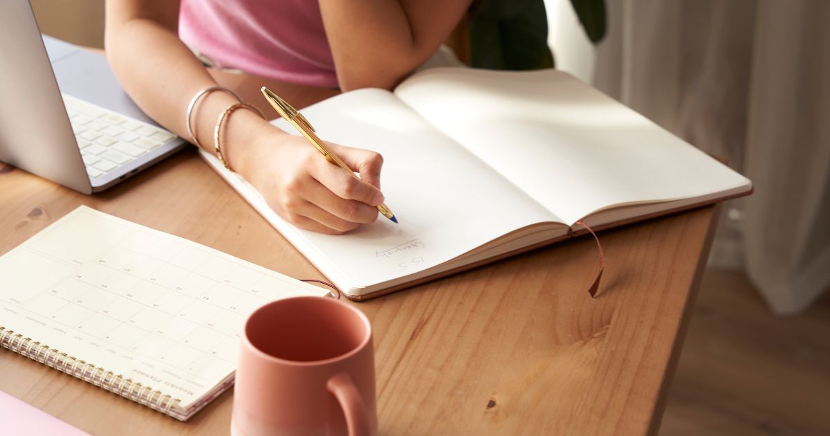ノートに書き込もうとする人の手元