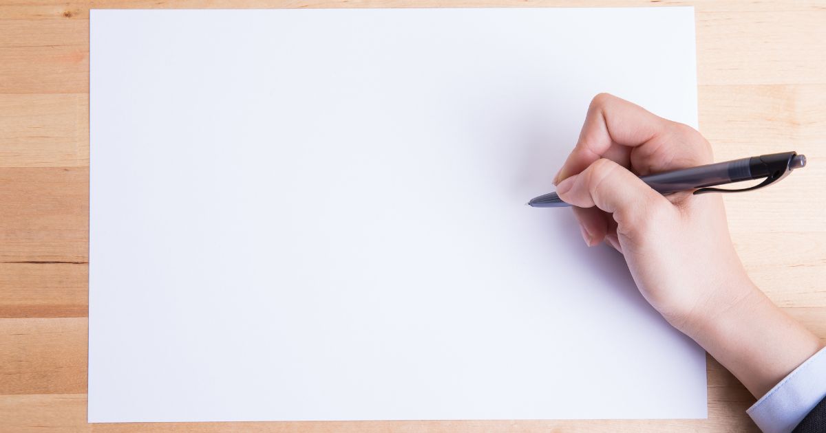 白紙に書き込もうとしている人の手元