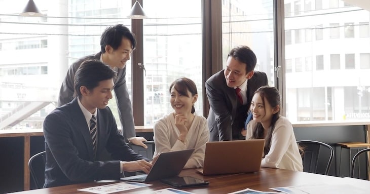 同僚と笑顔で打ち合わせしているイメージ