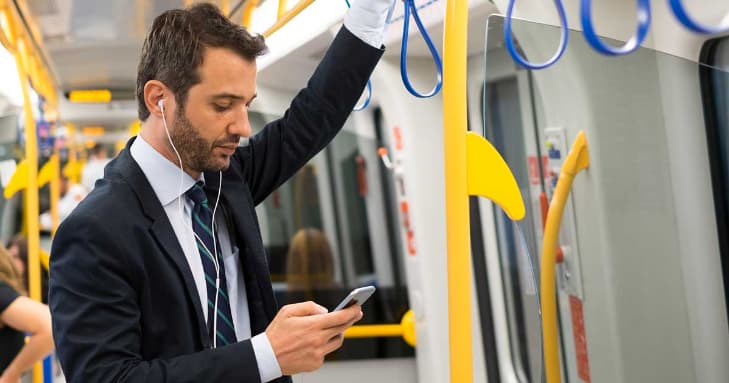 電車移動中に録音を聴く男性