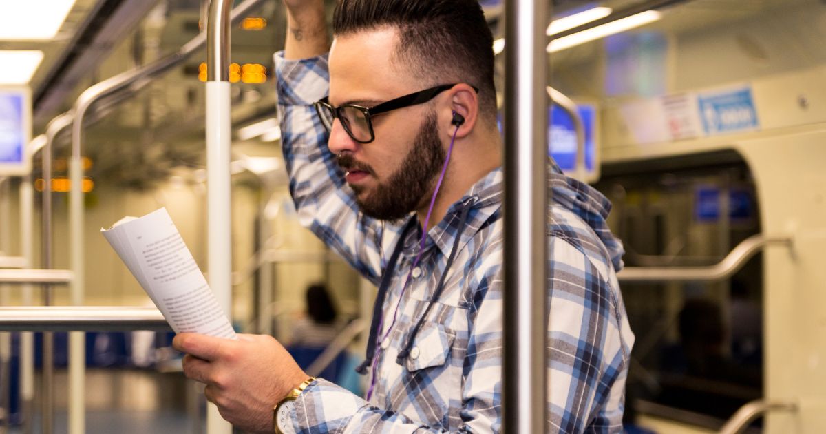 電車のなかで参考書を読む男性