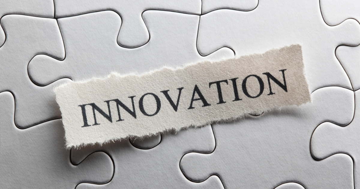 ジグソーパズルのピースの上に「INNOVATION」と書かれた紙片が置かれ、イノベーションの構成要素を表している