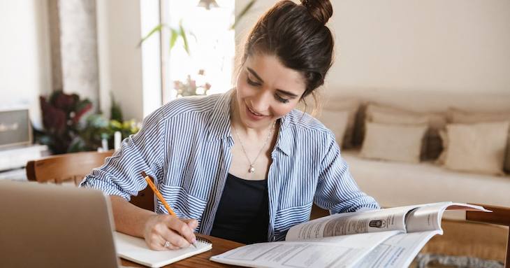 ノートを使って勉強している女性