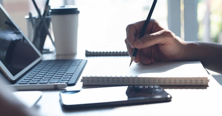 机に向かって勉強している男性