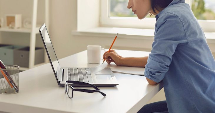 机に向かって勉強している女性