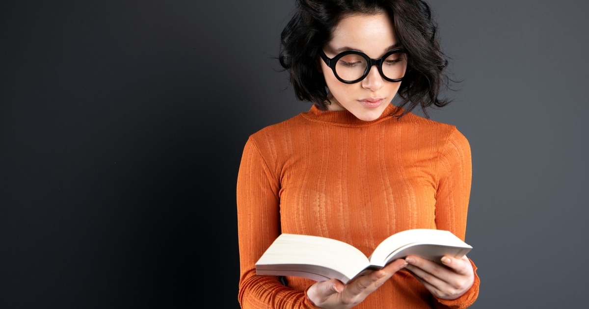黒い壁の前で読書をする女性