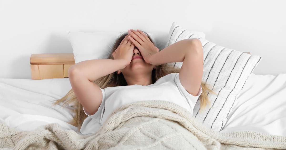 朝ベッドで憂鬱そうにしている人物