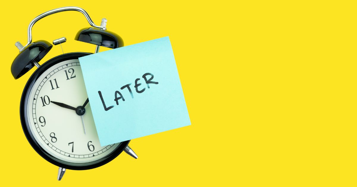 目覚まし時計に「LATER」と書かれたポストイットが貼られている