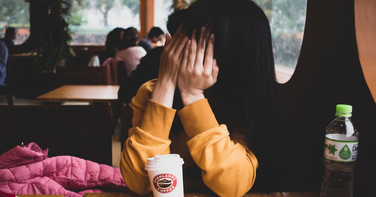 顔を手で覆っている女性