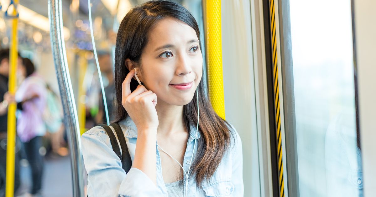 電車内でイヤホンをつけている女性